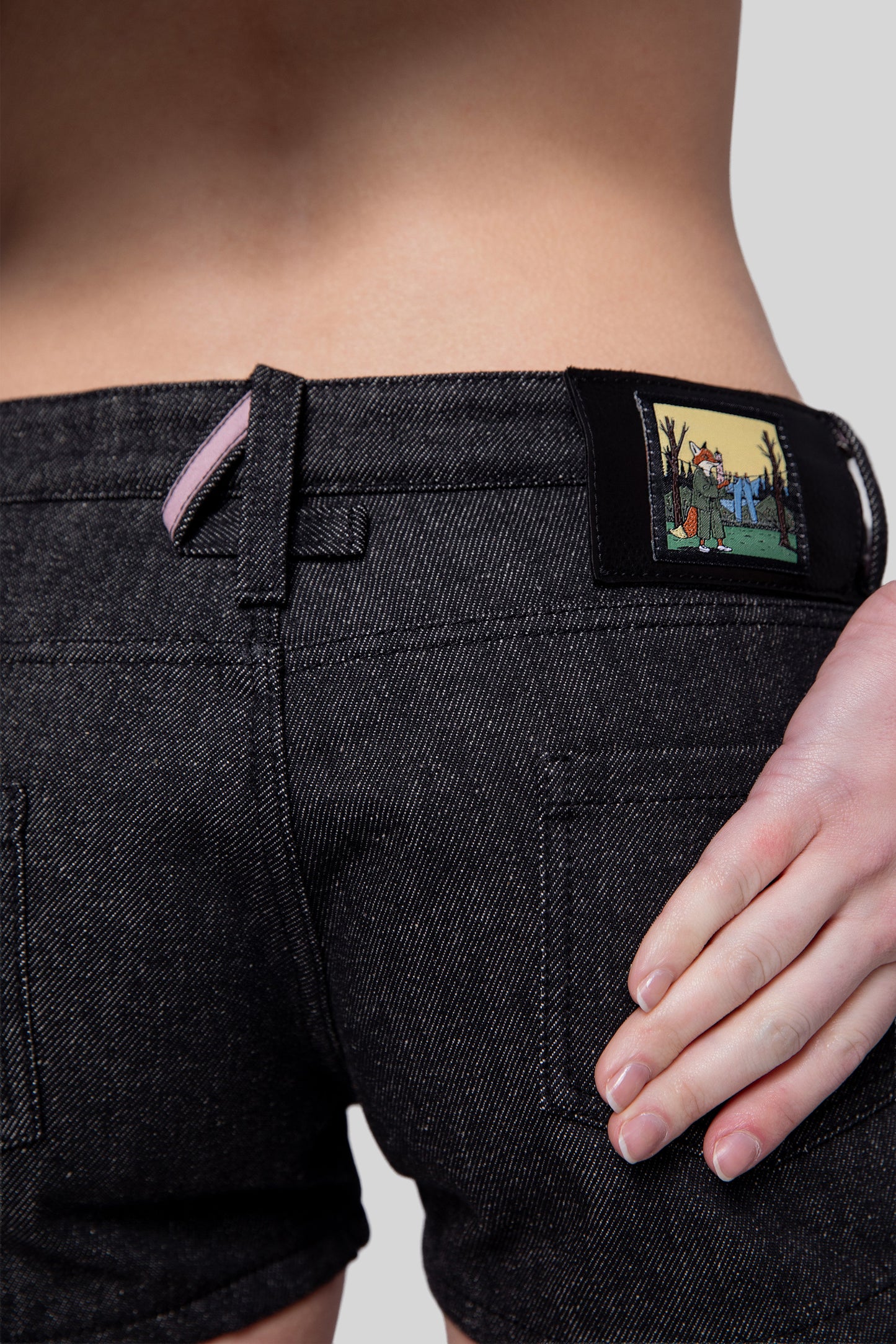 Close-up of 4-shaped belt loop and fox patch on 4Sight shorts