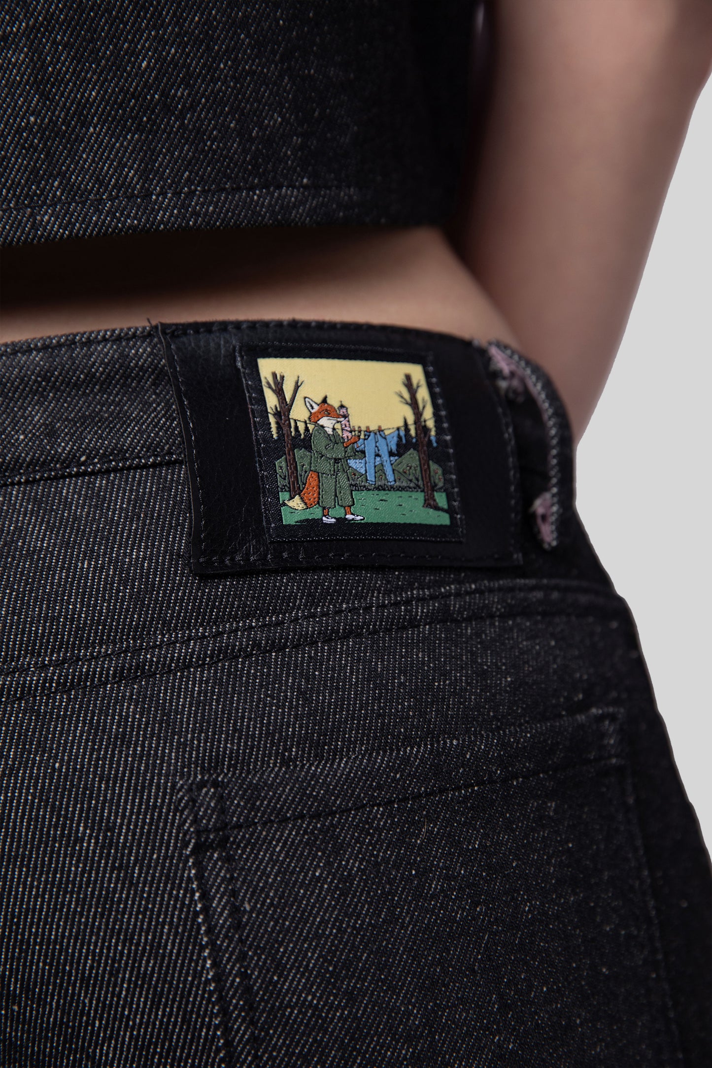 Close-up of fox illustration patch on waistband of Squid jeans