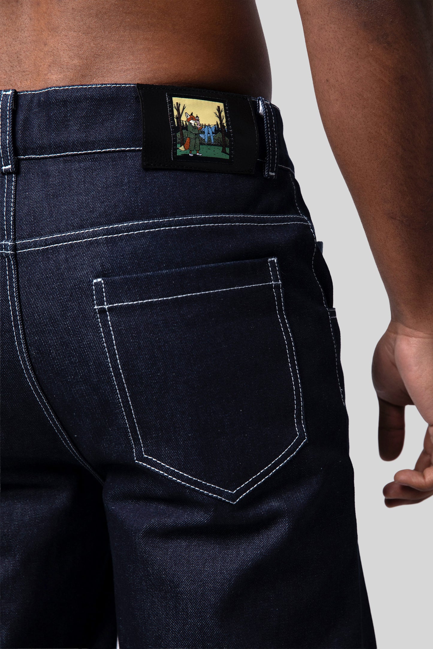 Close-up of fox illustration patch on back waistband of 4Front jeans