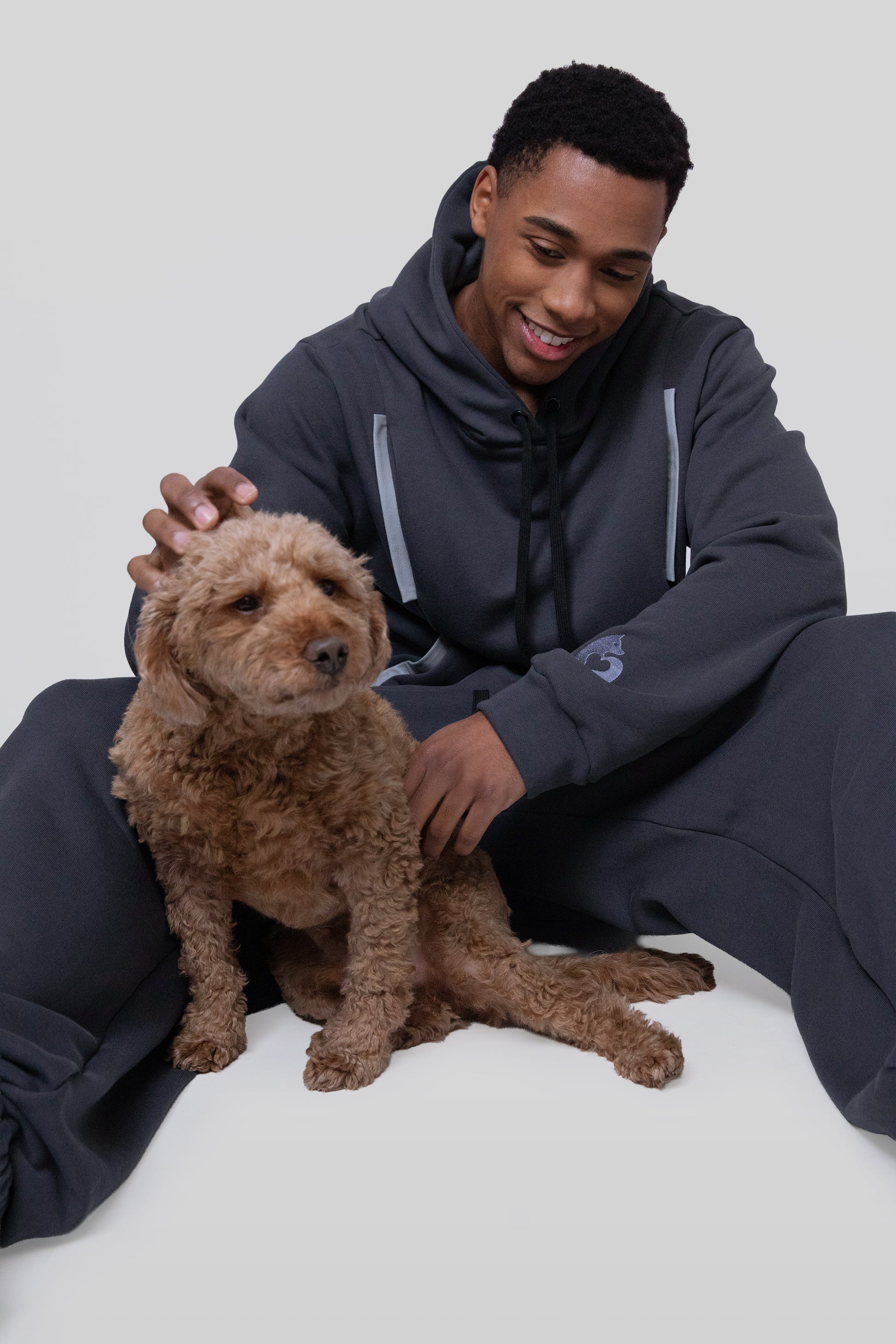 [card:men-secondary] Model seated wearing Anchor hoodie with relaxed fit