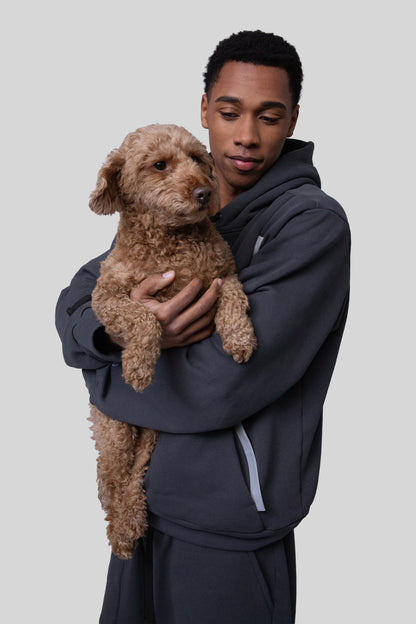 Model wearing Anchor hoodie in deep grey holding dog