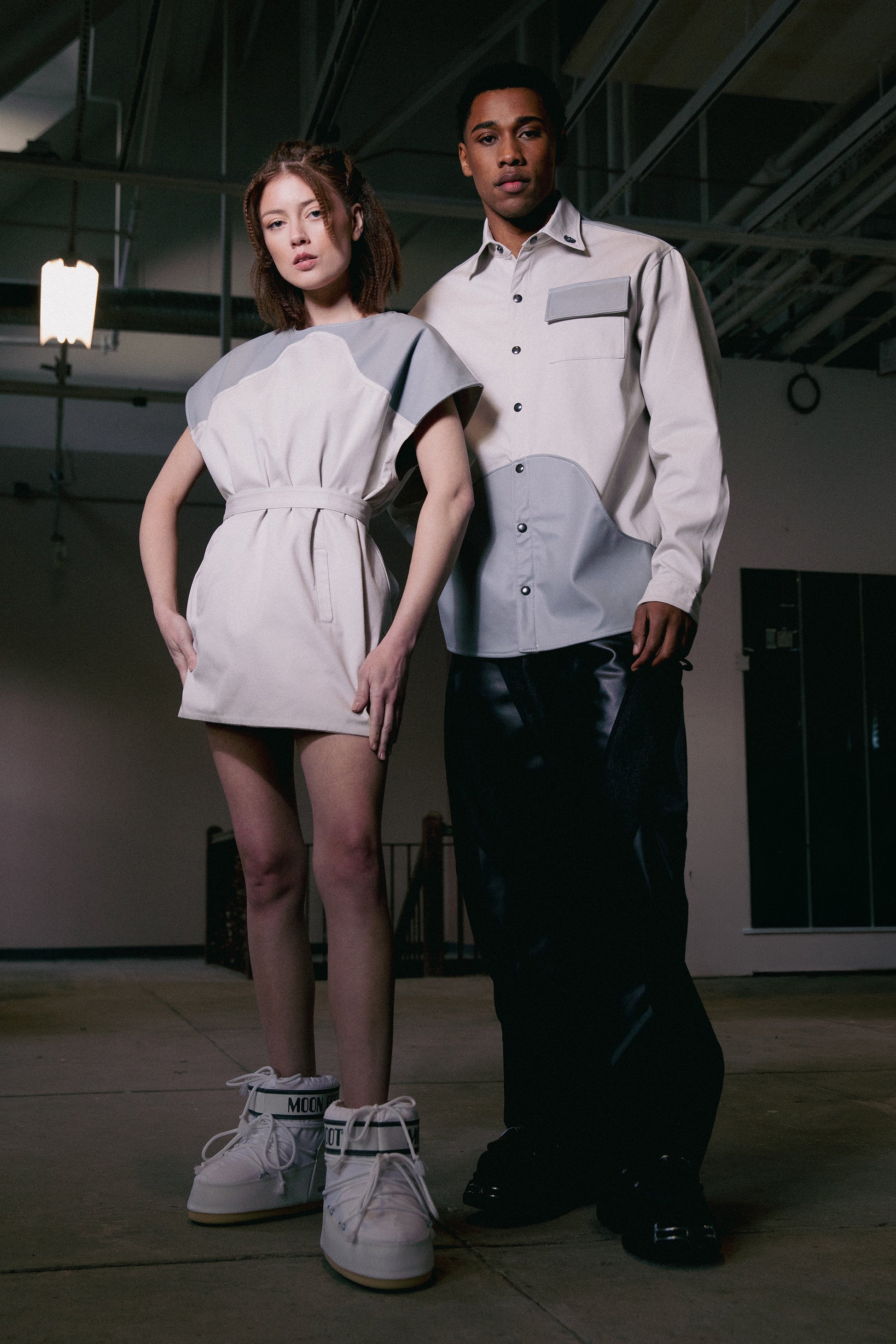 Model wearing 4NML Chameleon dress in fitted configuration with belt, next to model wearing 4NML Out of Pocket shirt and Bloom Jean
