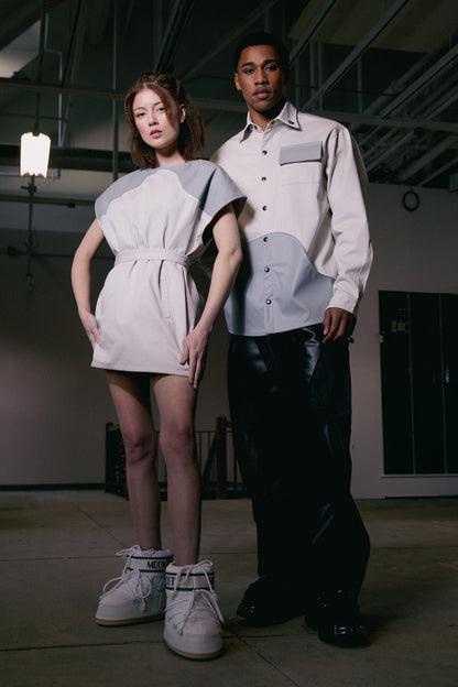 Model wearing 4NML Chameleon dress in fitted configuration with belt, next to model wearing 4NML Out of Pocket shirt and Bloom Jean