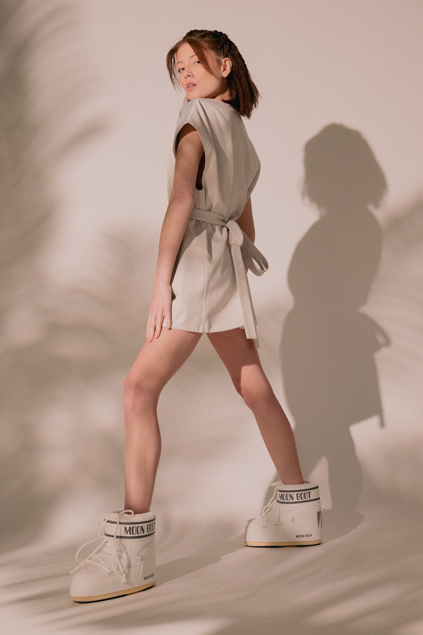 Model turning in Chameleon dress with fitted silhouette and belt