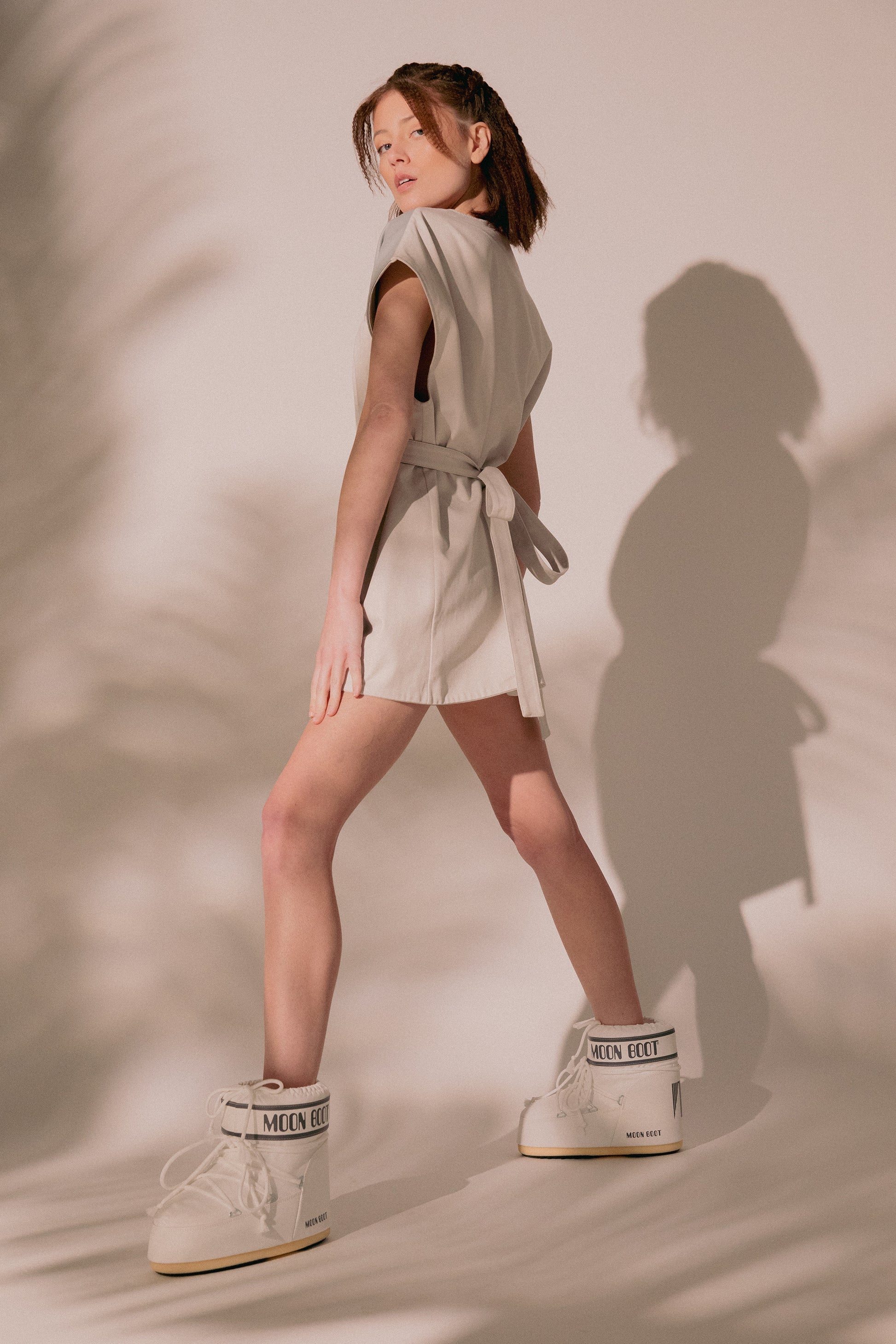 Model turning in Chameleon dress with fitted silhouette and belt