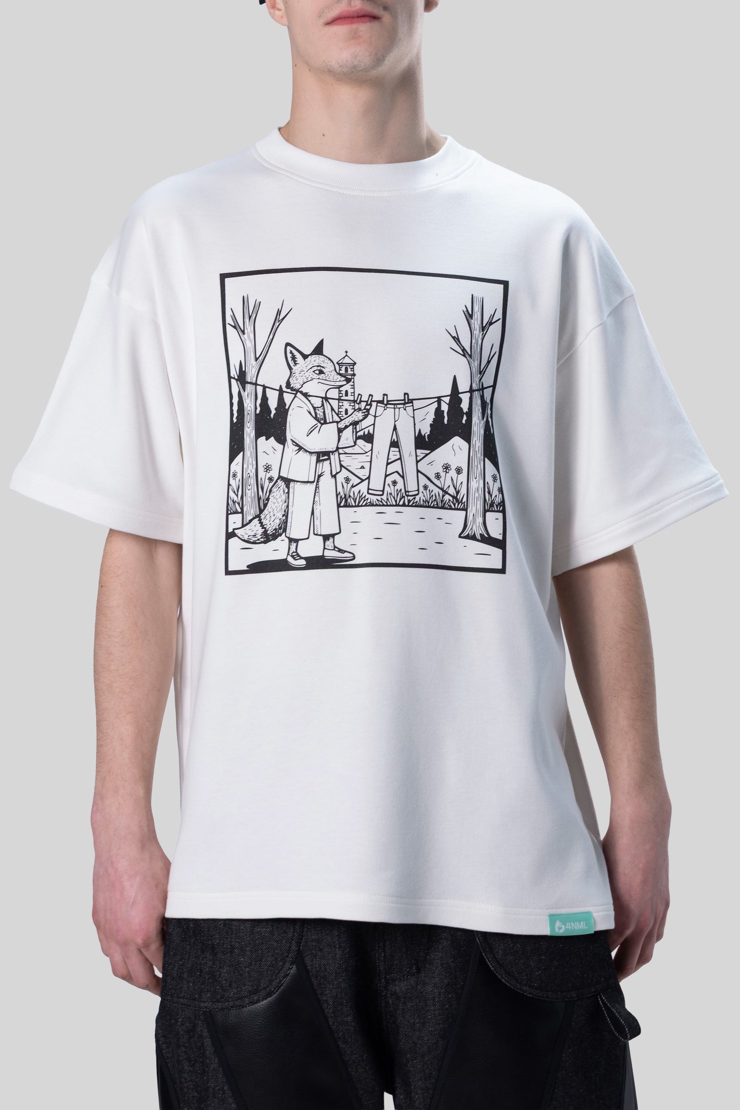 [card:men-secondary][card:all-secondary] Model wearing 4NML Men's Lineage Tee, front view showing illustration of fox hanging jeans on clothes line