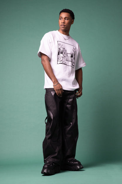 [card:men-primary][card:all-primary] Model standing in white Supima cotton Lineage Tee with black graphic and 4NML Bloom Jean in carbon Candiani raw denim with black AppleSkin panels, full body