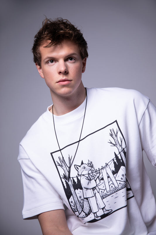 Model wearing 4NML Men’s Lineage Tee in white Supima cotton with black fox illustration