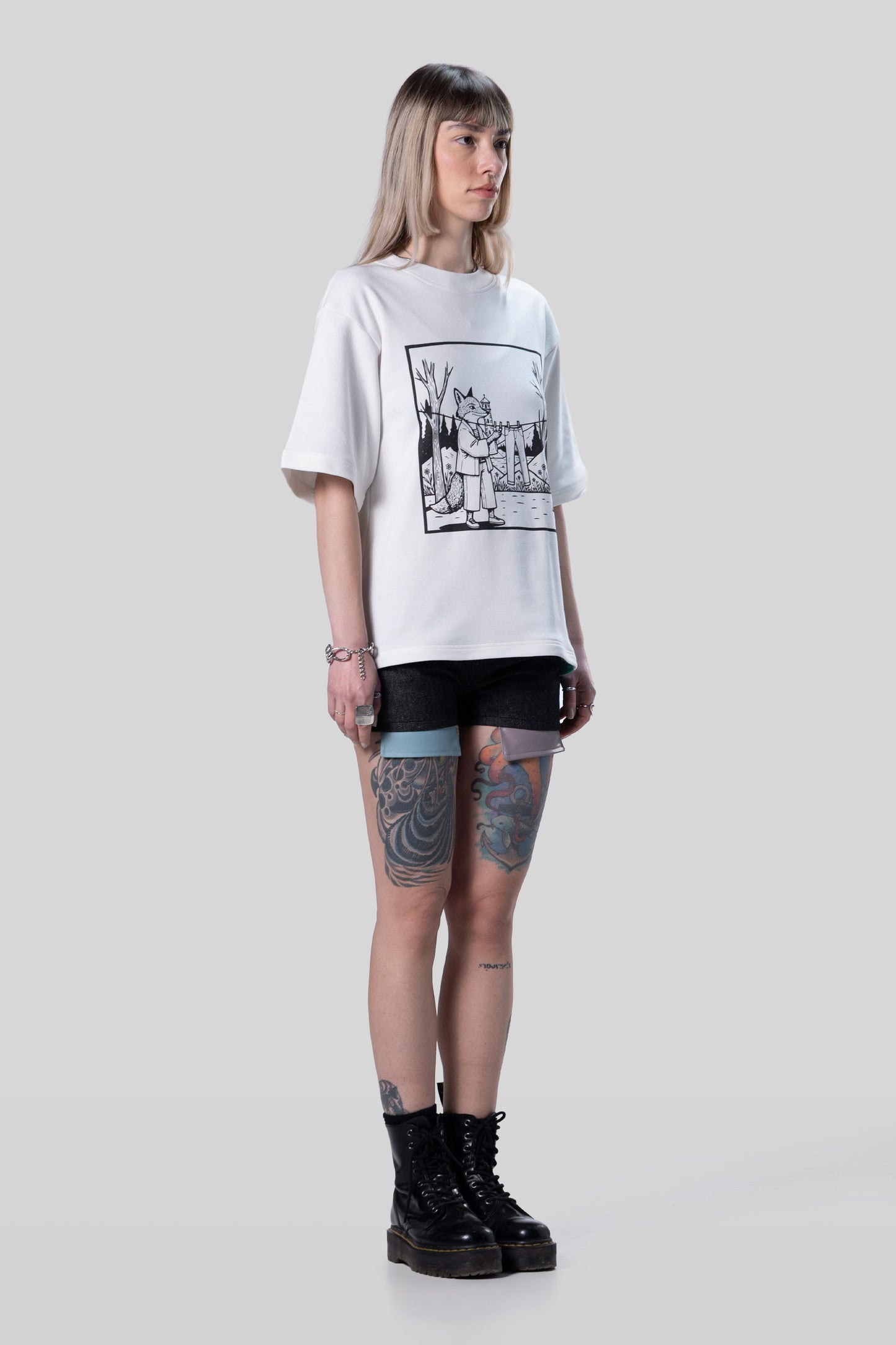 Angled full body view of white Supima cotton Women’s Lineage Tee with black graphic