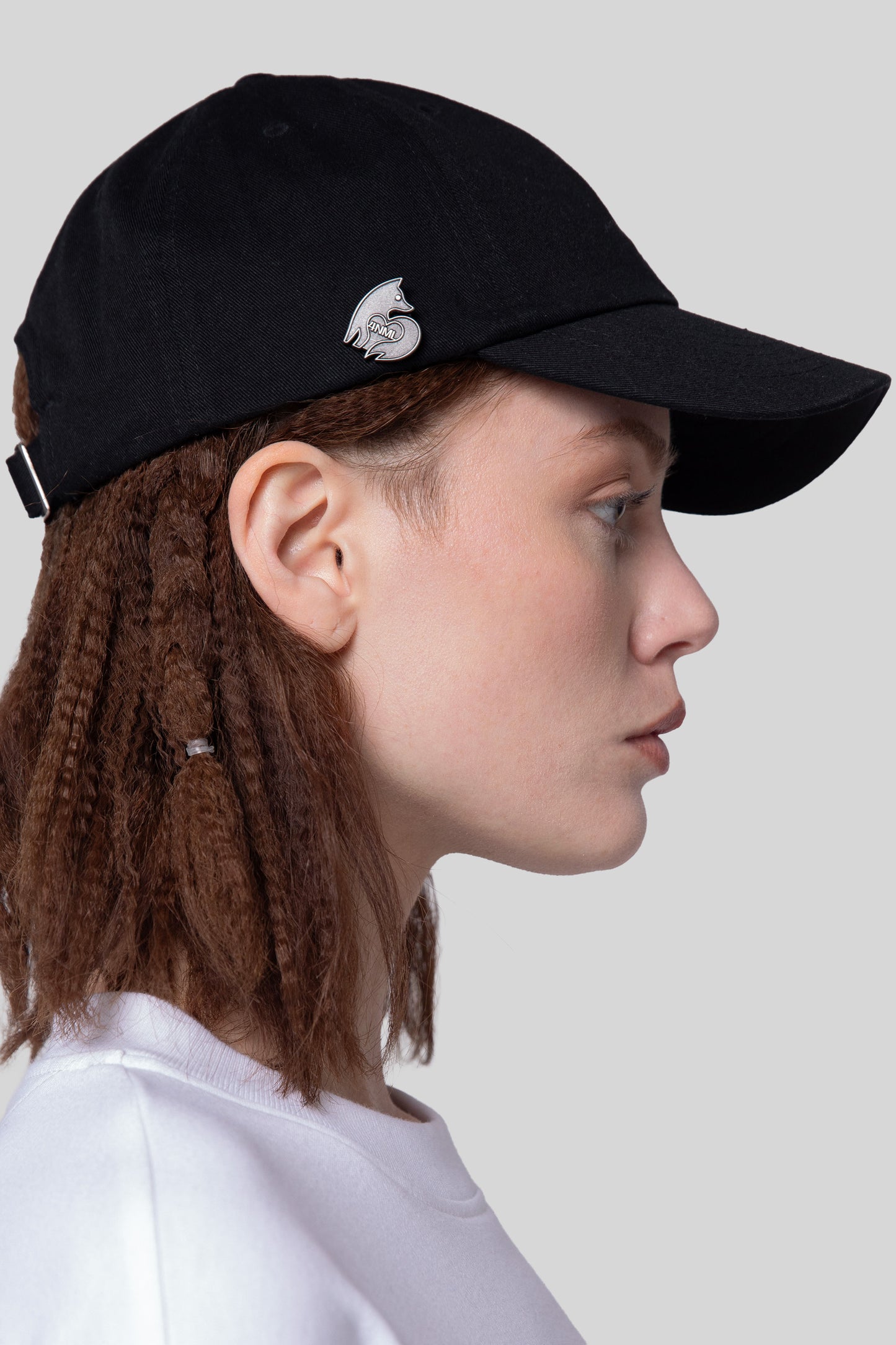 Side view of black No Cap hat with curved brim and die-struck 4NML logo pin