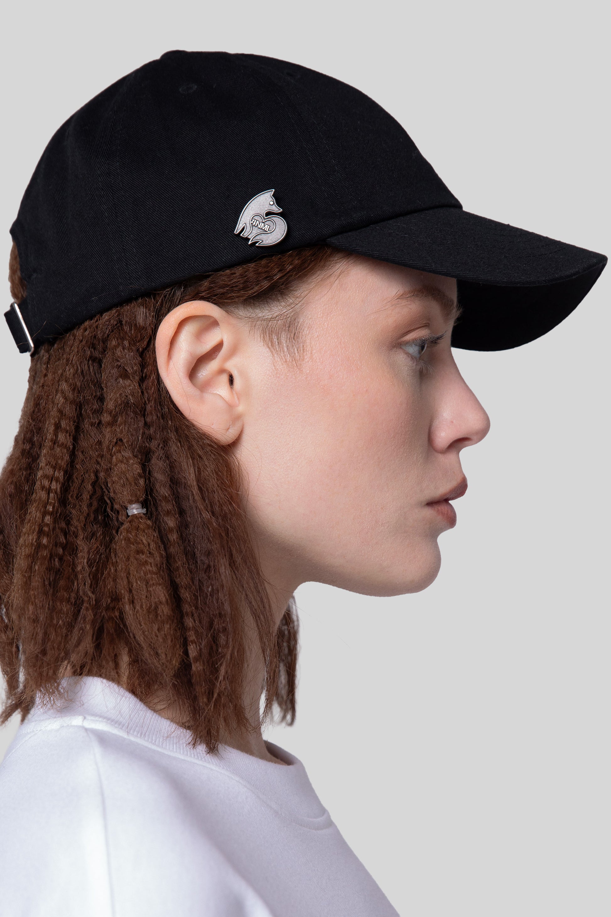 Side view of black No Cap hat with curved brim and die-struck 4NML logo pin