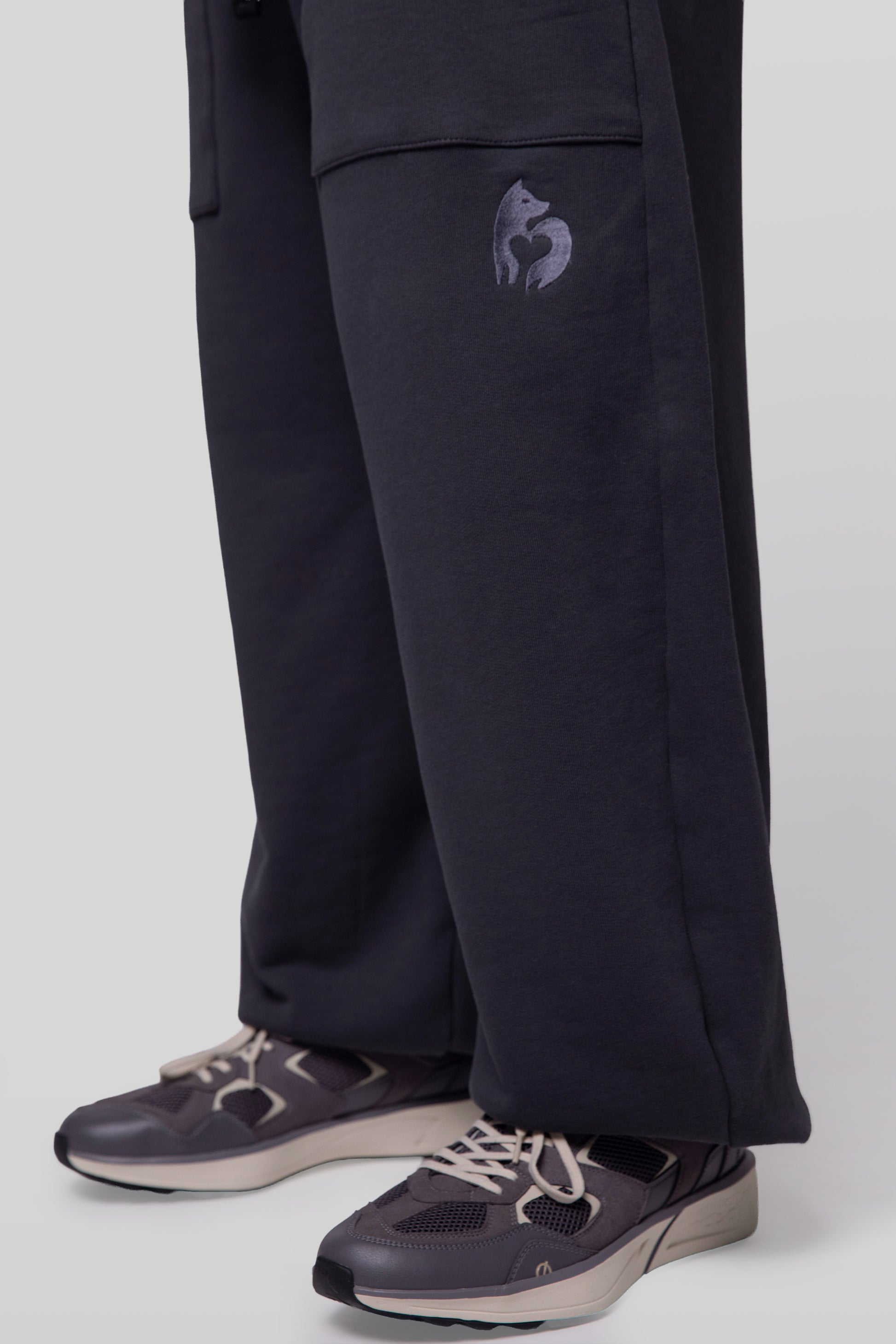 Close-up of 4NML logo embroidery under pocket on deep grey No Sweat pants