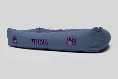 Low angled view of canvas cotton pet bed with lavender AppleSkin embroidery, blue base