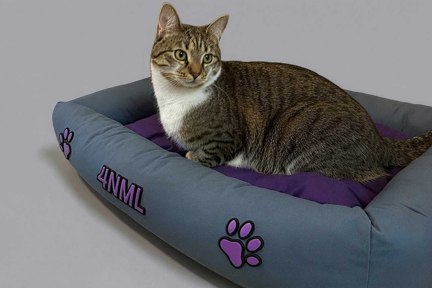 Cat resting on canvas cotton pet bed with lavender AppleSkin embroidery, blue base with purple cushion