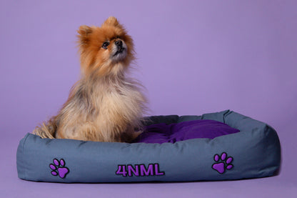 Dog resting on 4NML canvas cotton pet bed with lavender AppleSkin embroidery, blue and purple colorway