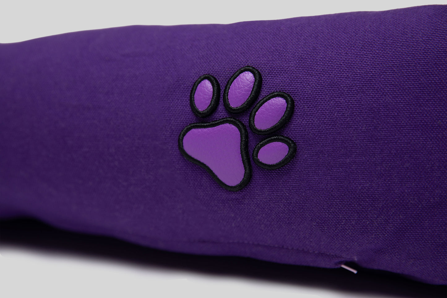 Close-up of lavender AppleSkin paw embroidery on purple canvas cotton pet bed