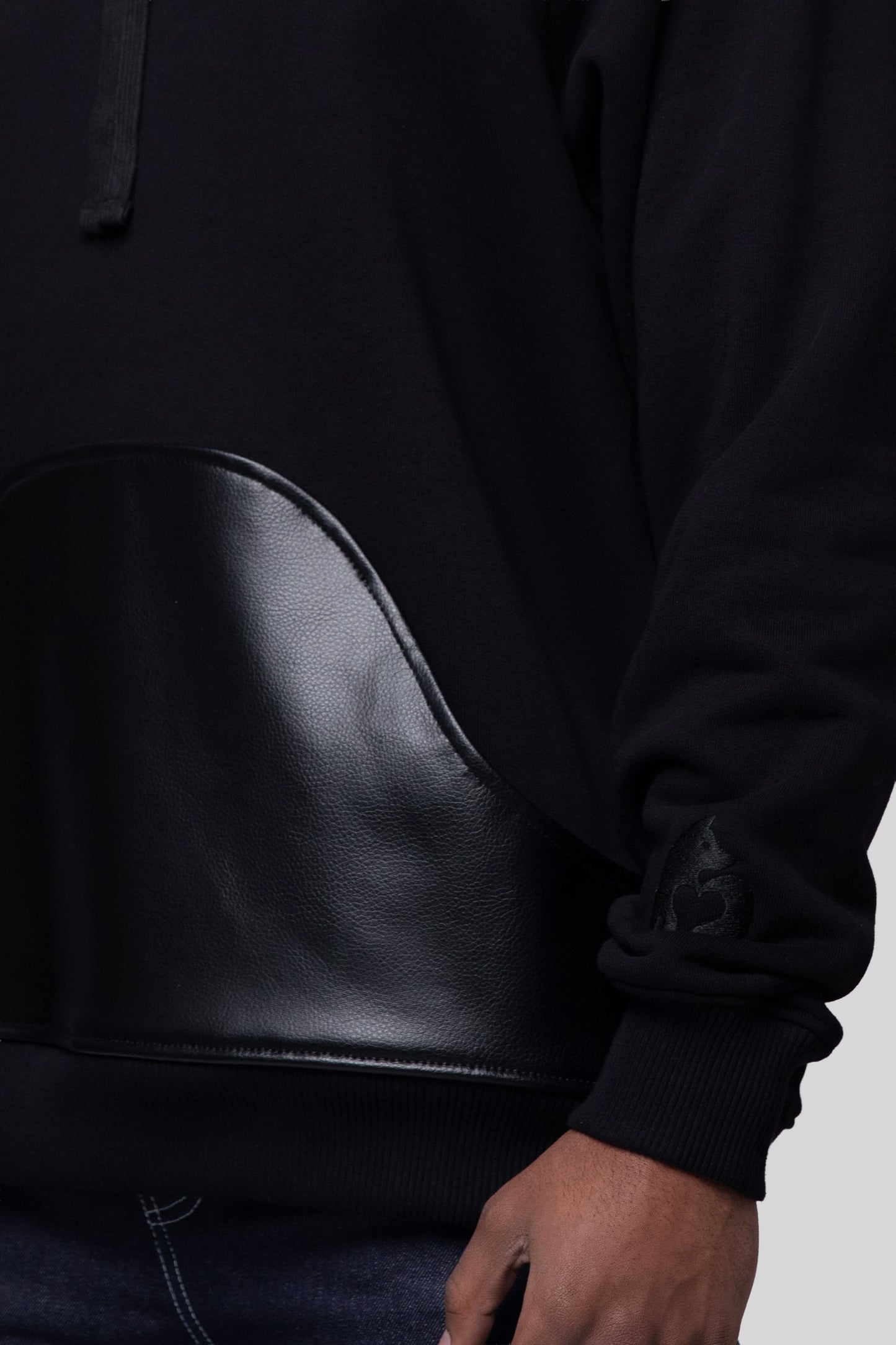 Close-up of AppleSkin front pouch and sleeve embroidery on Shadow hoodie