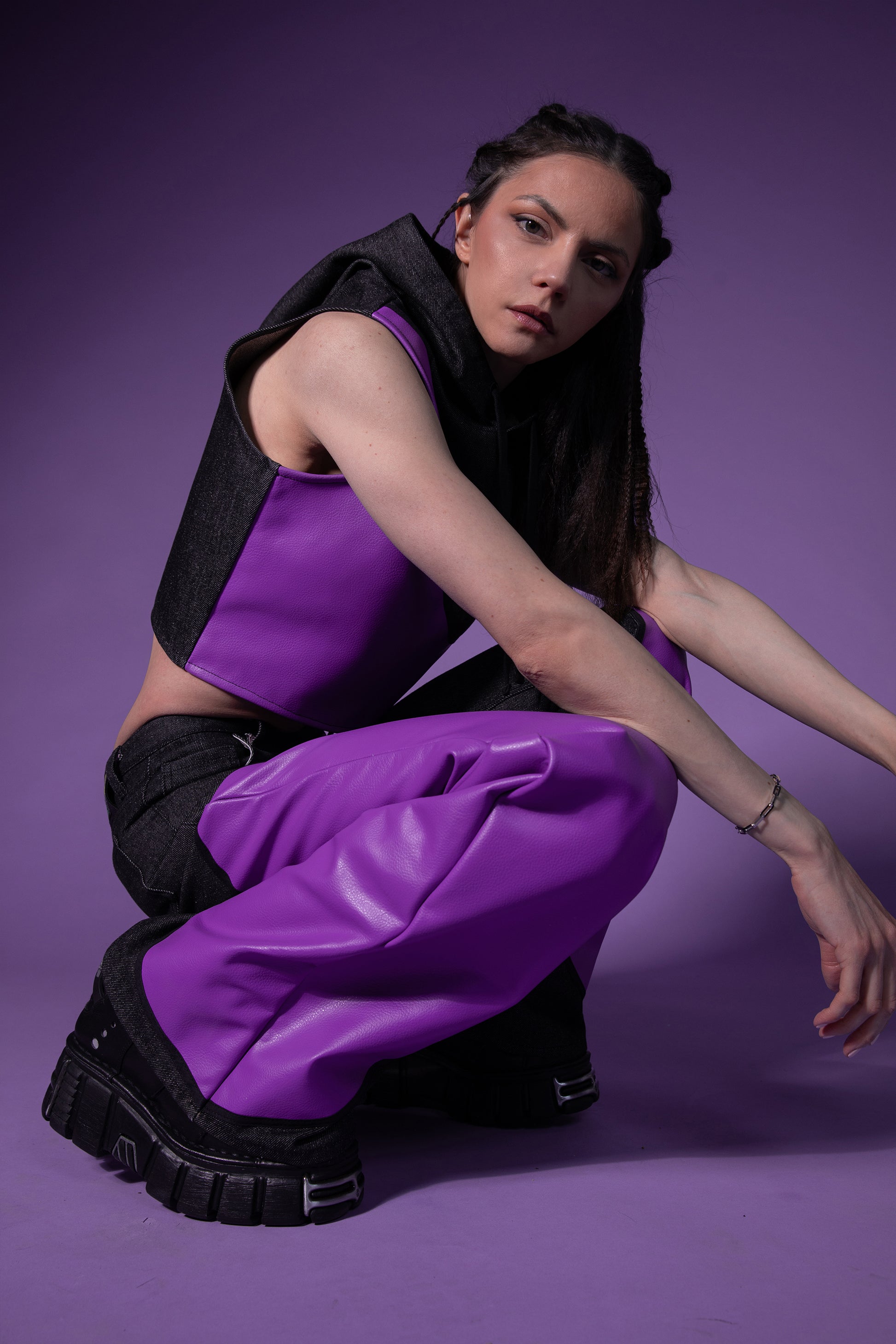 [card:women-primary][card:all-primary] Model crouching in Squid jeans with panelled silhouette in carbon raw denim