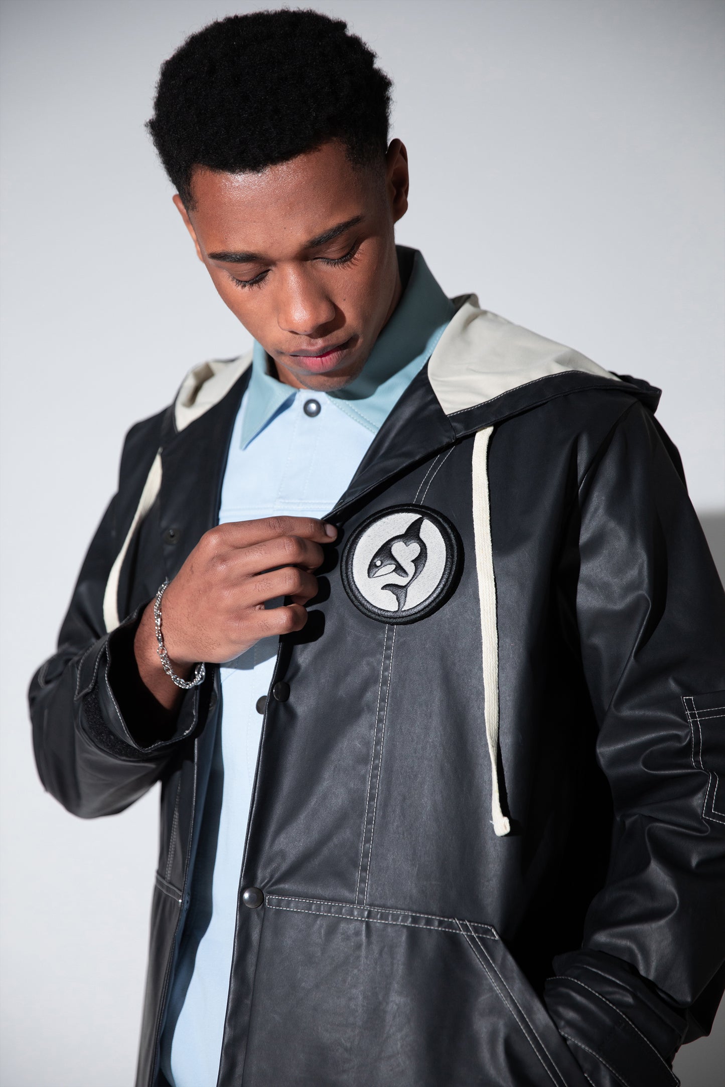 Close-up of removable animal badge on Totem coat in dark grey