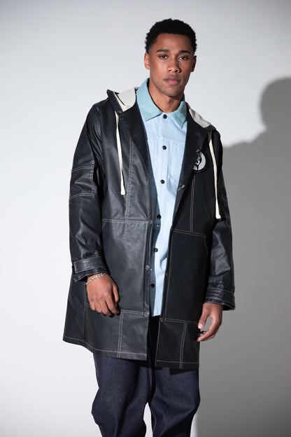 Full body view of Totem coat layered over shirt, dark grey waterproof fabric