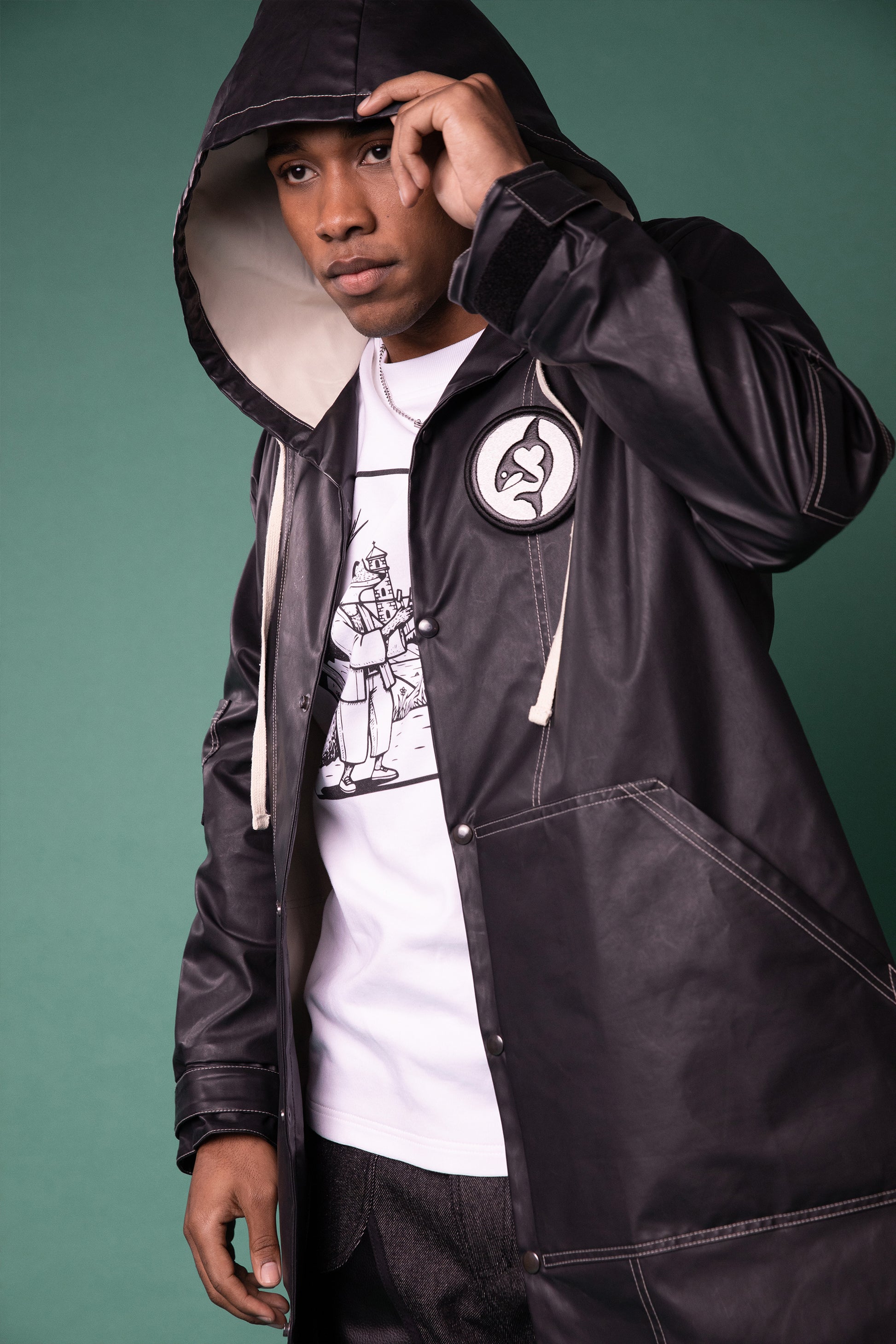 [card:men-primary][card:all-primary] Model wearing 4NML Totem coat in dark grey waterproof fabric with hood and removable badge